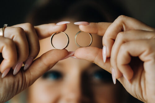 woman holding up two rings to show ring sizing
